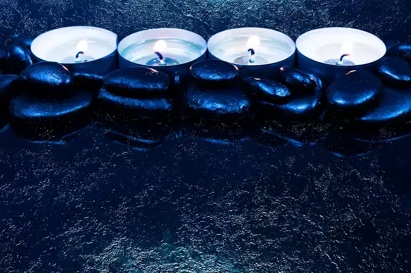 4 bougies cernées de pierres noires